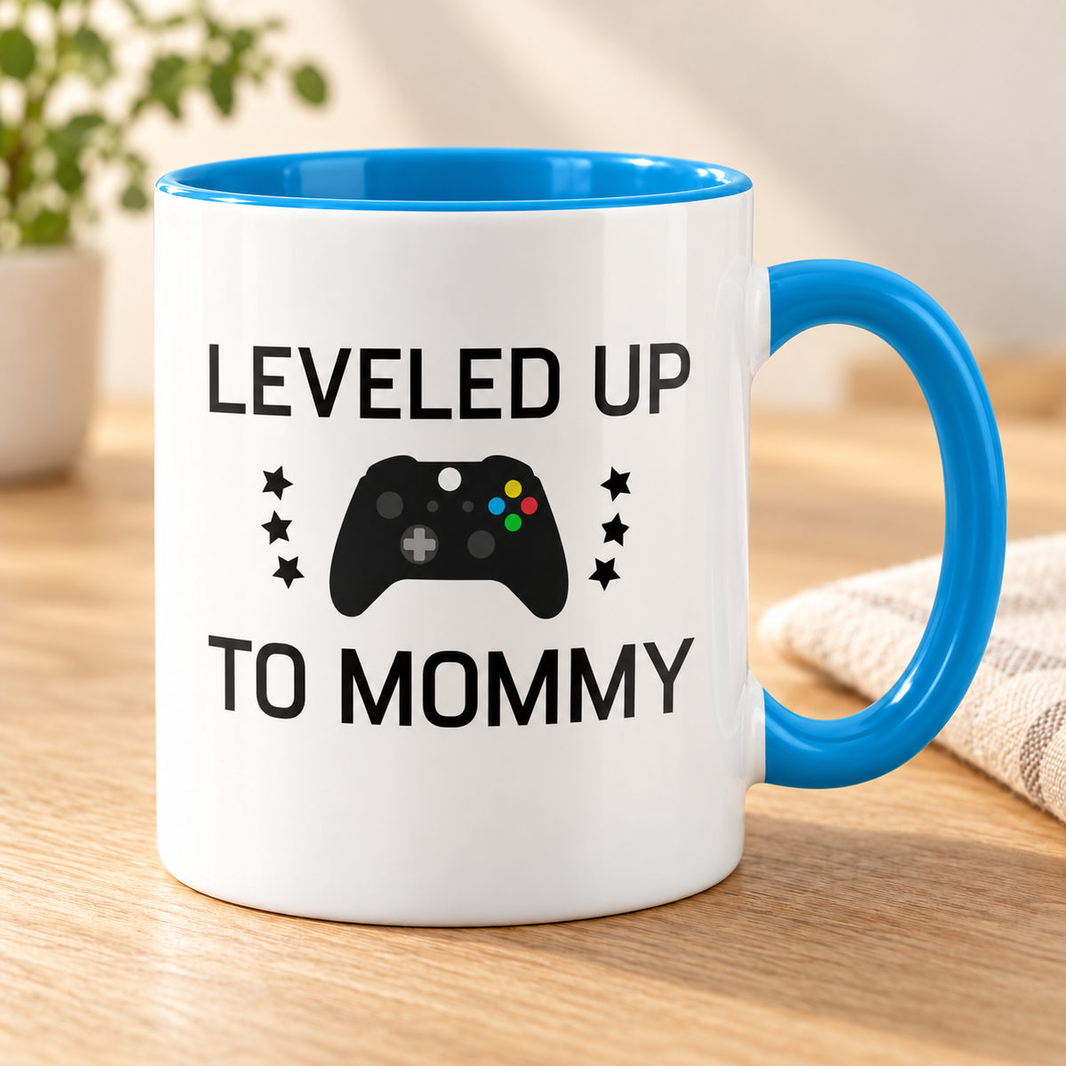 Leveled Up To Mommy 11 oz ceramic mug, blue handle and interior, controller graphic