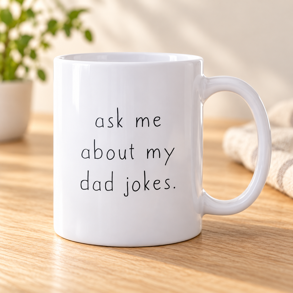 White 11 oz "Ask Me About My Dad Jokes" mug on a sunlit oak table