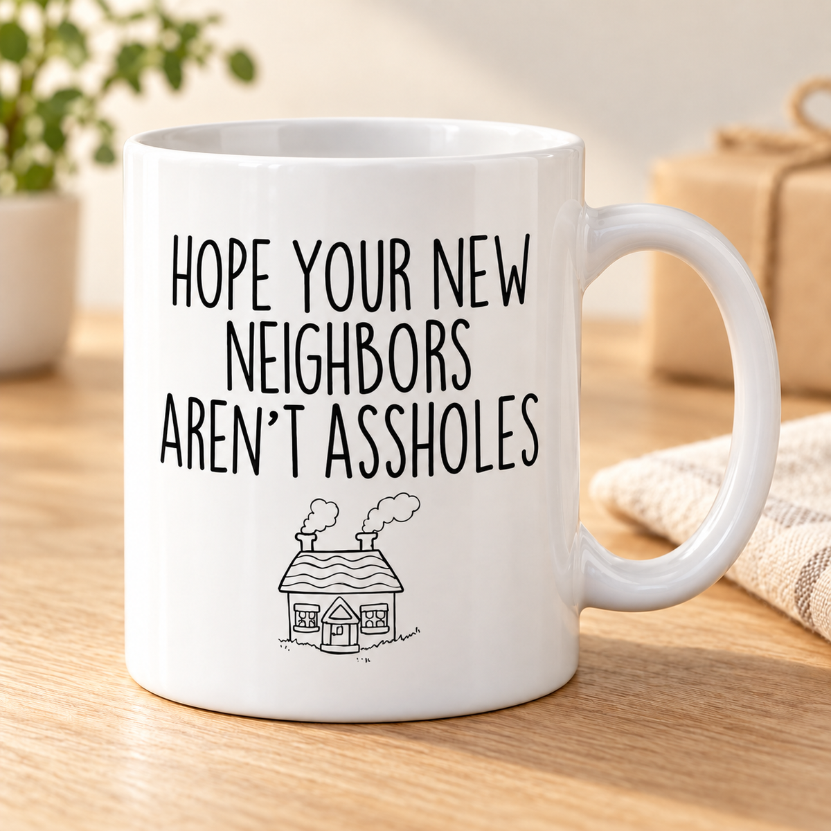 Funny Housewarming Gift: Hope Your New Neighbors Aren't Assholes Coffee Mug — mug on a sunlit oak table