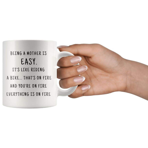 Being A Mother Is Easy. It's Like Riding A Bike... That's On Fire. And Your On Fire. Everything Is On Fire Coffee Mug - BackyardPeaks