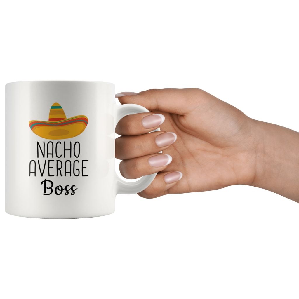 Hand holding a white Nacho Average Boss mug by its handle