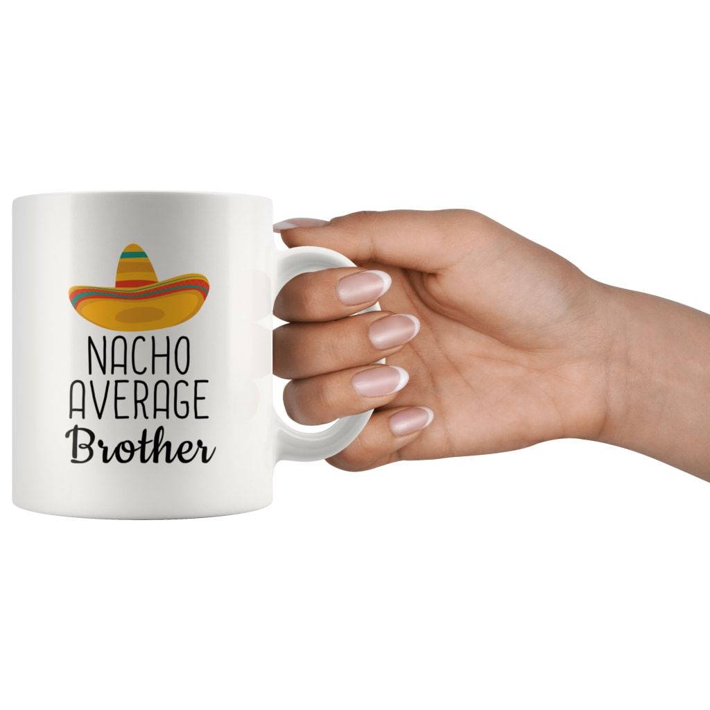 Hand holding a white Nacho Average Brother mug by its handle